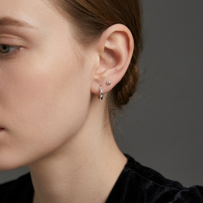 Rhodium 2mm sleeper huggies worn on ear, small round hoop earring