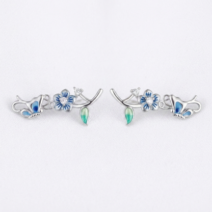 Butterfly climber earrings, silver-tone with blue enamel wings, crystal centers, and green drops.