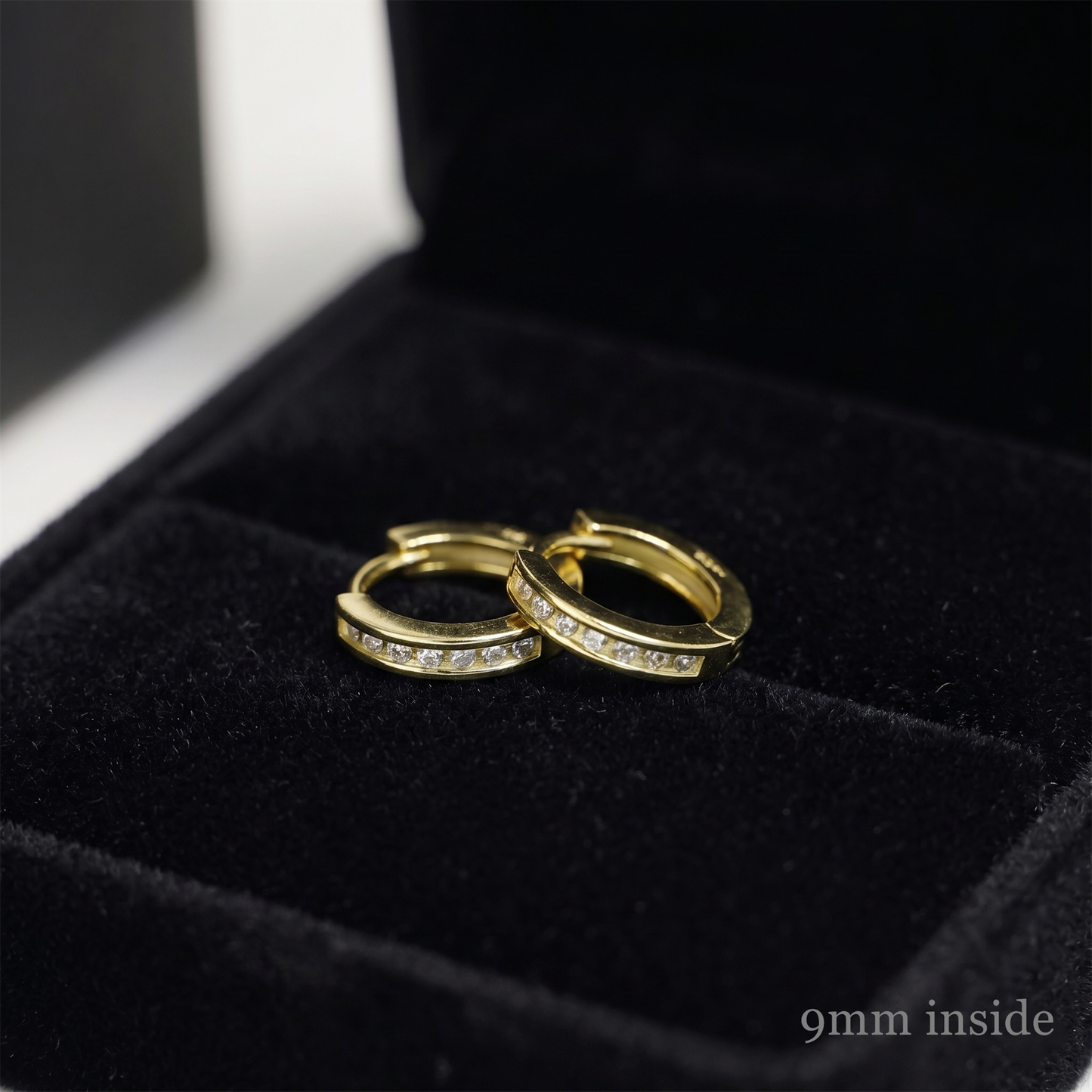Gold tone Channel Huggie hoops with inset stones, stacked angle on display