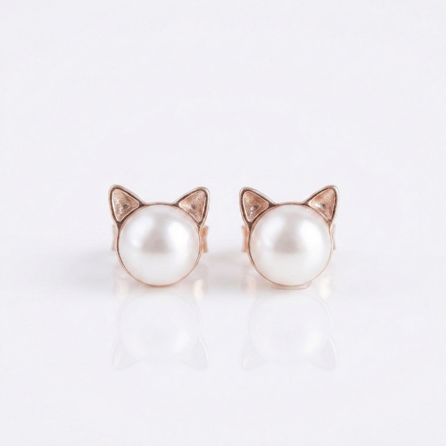 Cat pearl stud earrings with rose gold-tone cat ear frames and small diamond-like details
