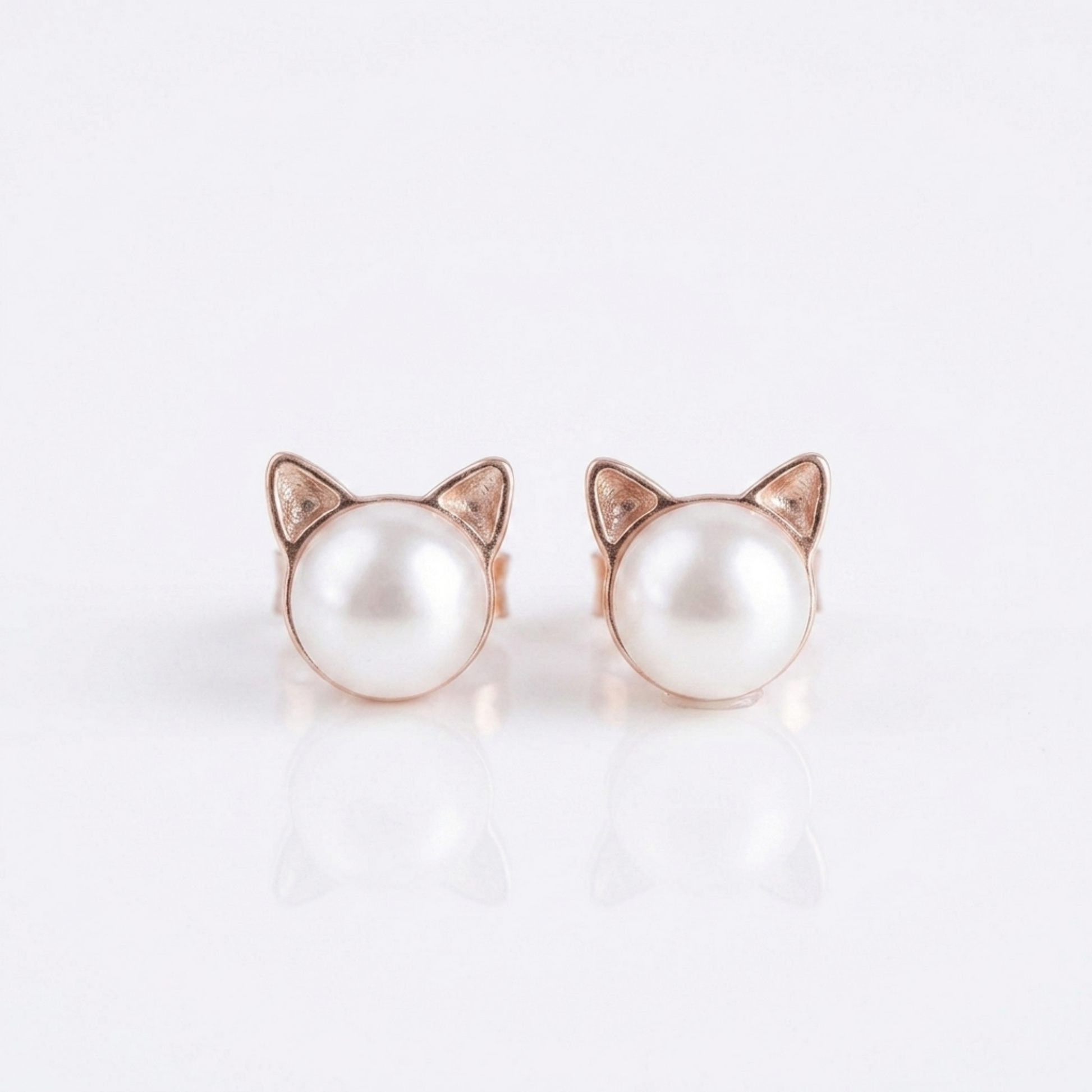 Cat pearl stud earrings with rose gold-tone cat ear frames and small diamond-like details