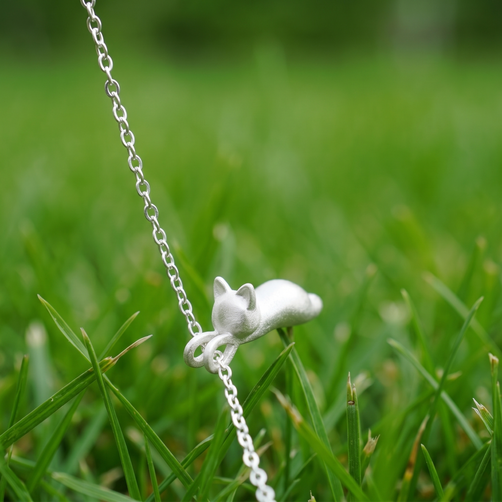 Cat pendant necklace with small curled-tail cat charm on silver chain
