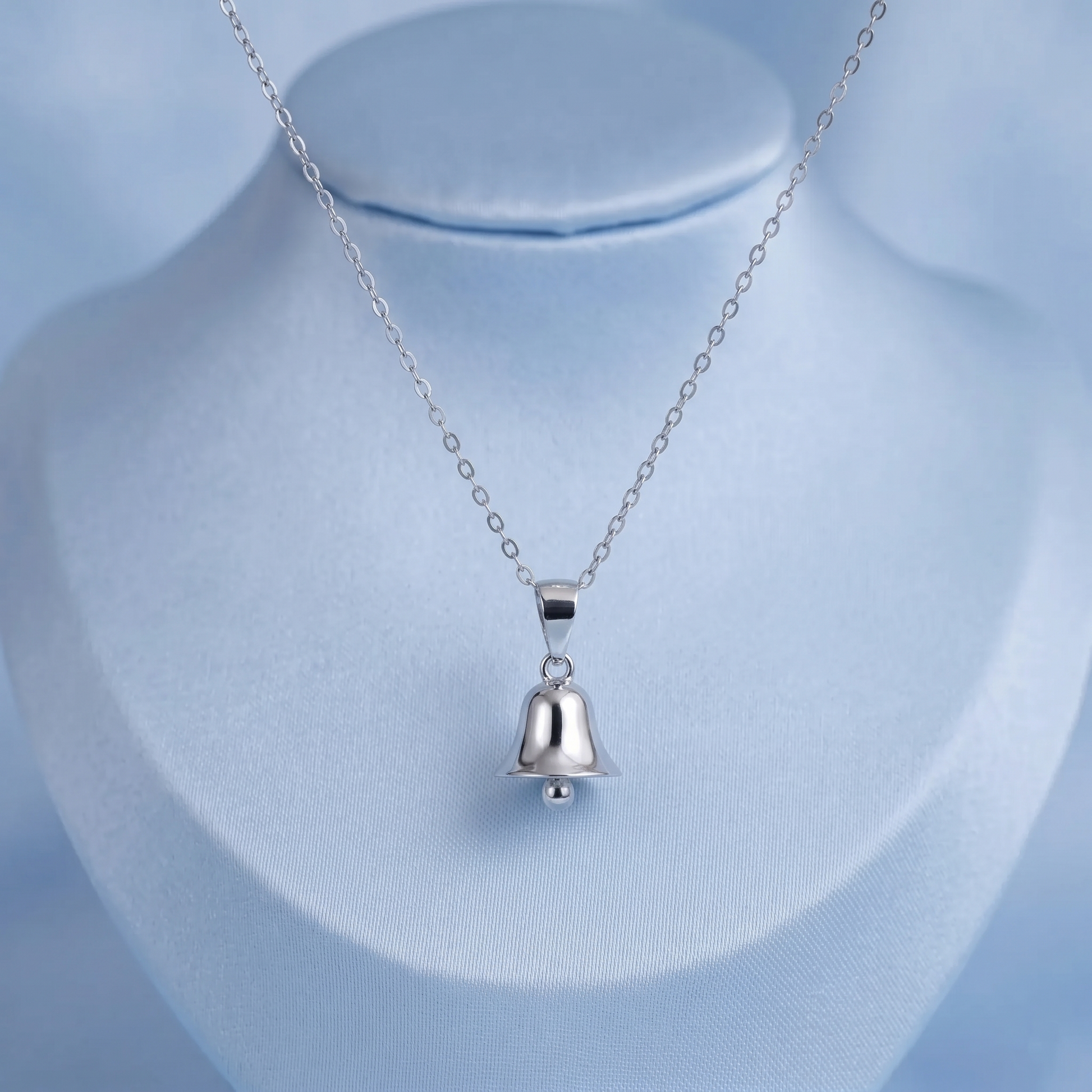 Jingle bell pendant necklace on bust, silver bell charm centered on link chain