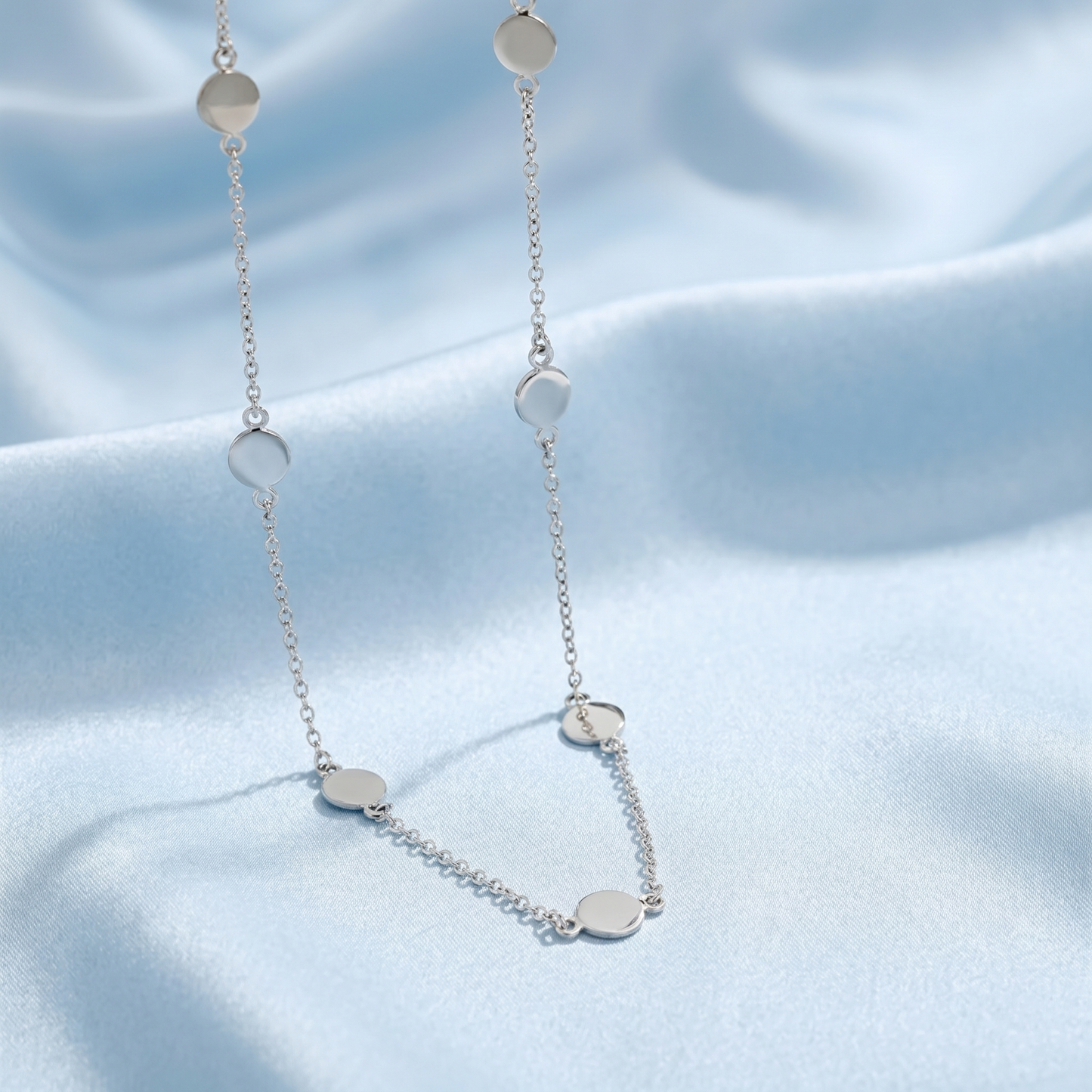 Silver-tone choker with multiple round disc charms spaced along the chain