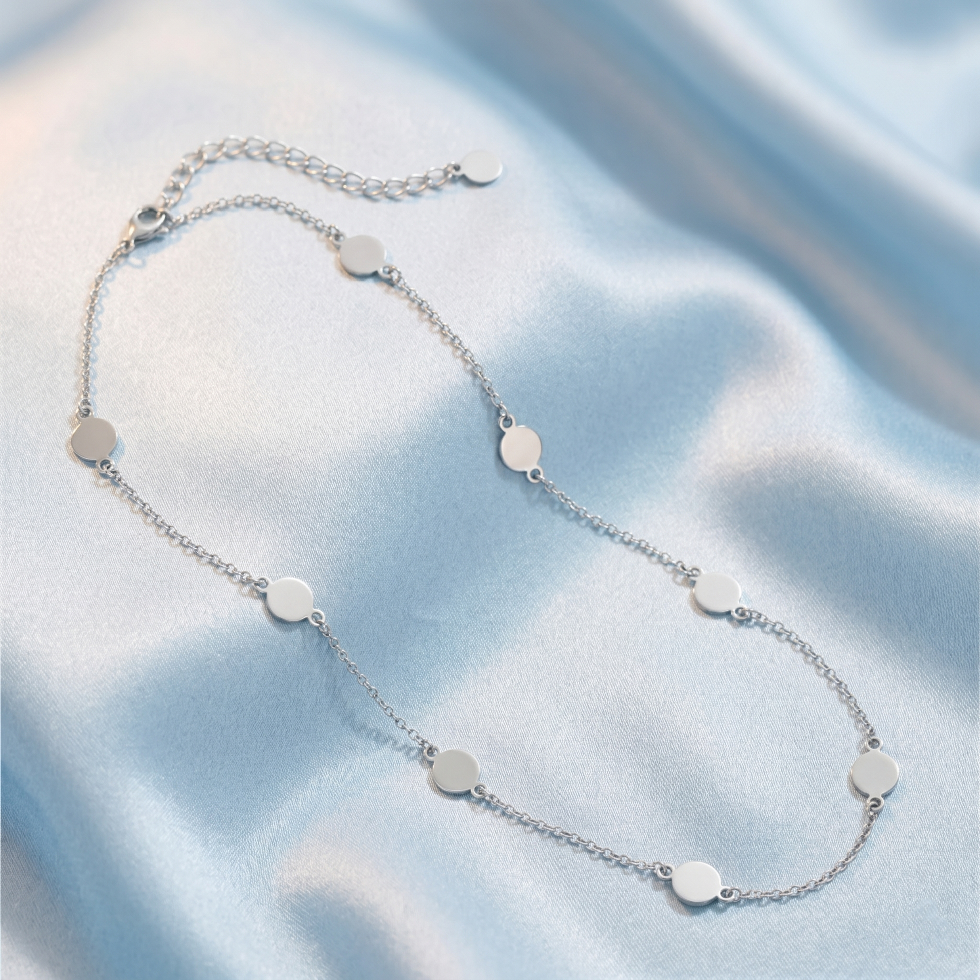 Round disc choker necklace laid flat, silver-tone chain with clasp