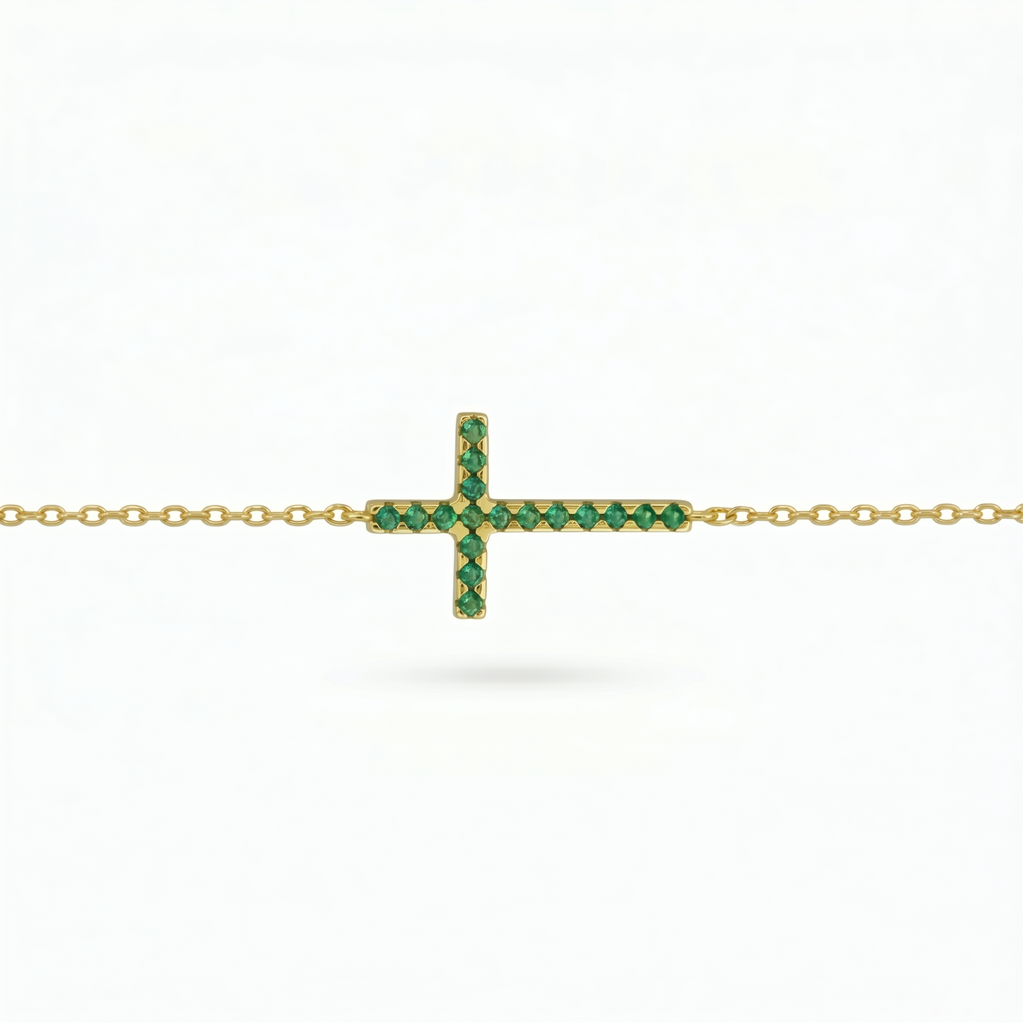 Green CZ cross pendant on gold-tone chain, sideways bar cross design