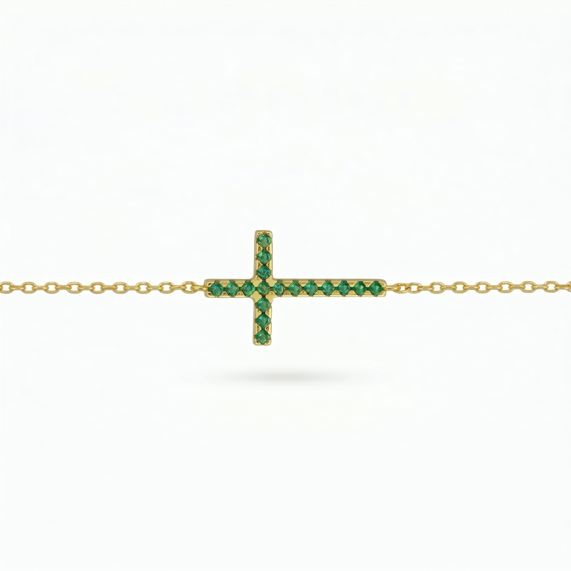 Green CZ cross pendant on gold-tone chain, sideways bar cross design