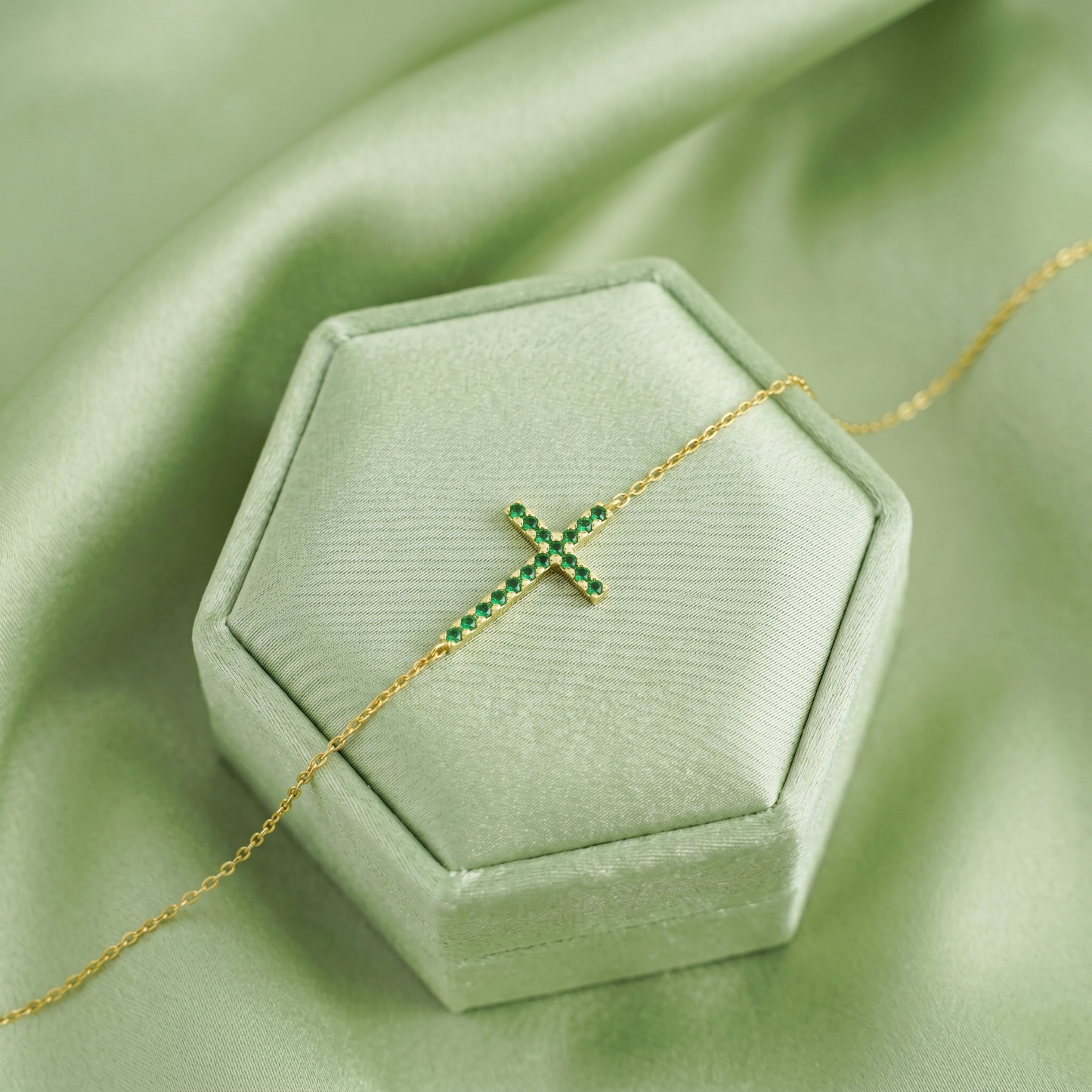 Green CZ cross necklace on gold-tone chain with stones in bar cross shape
