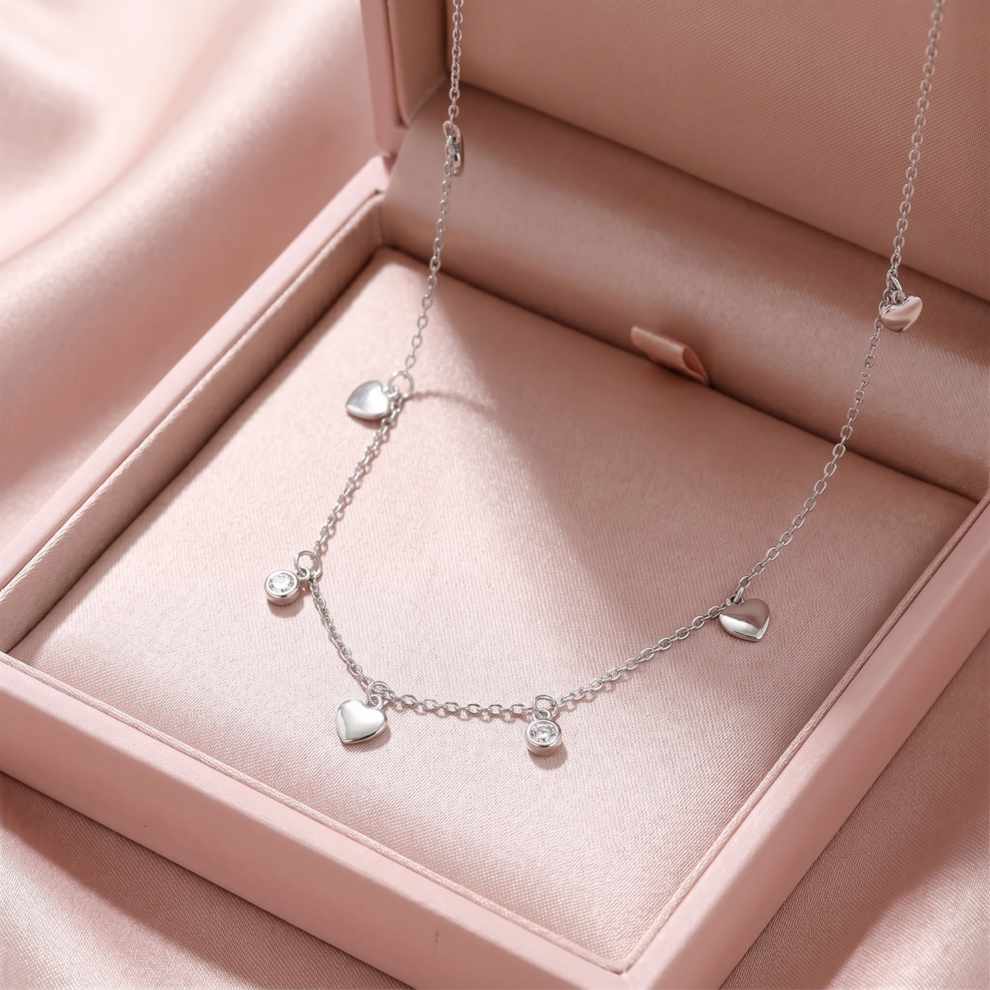 Silver-tone mini heart CZ choker with five heart charms and small round CZ discs
