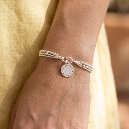 Shiny Disc Star Charm disc pendant with stars on a silver bracelet