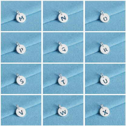 Silver hollow alphabet disc charm set with letters M–X shown on loop bails