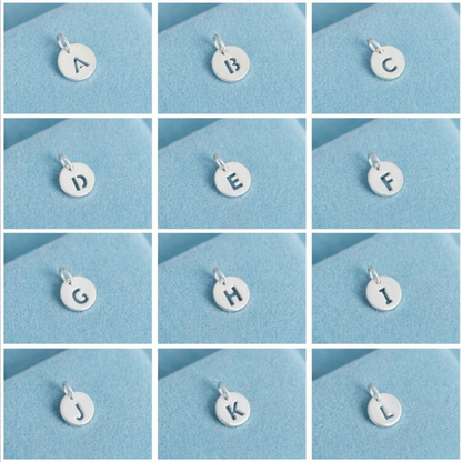Silver hollow alphabet disc charm set with letters A–L shown on loop bails