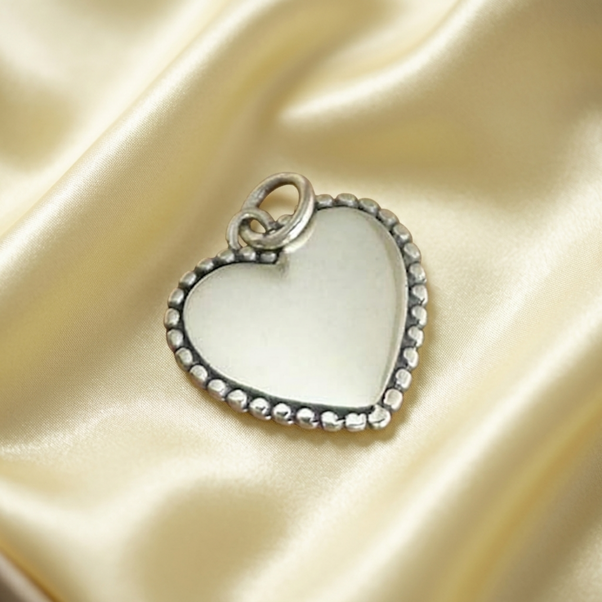 Heart charm pendant with beaded rim, round bezel, and hanging loop
