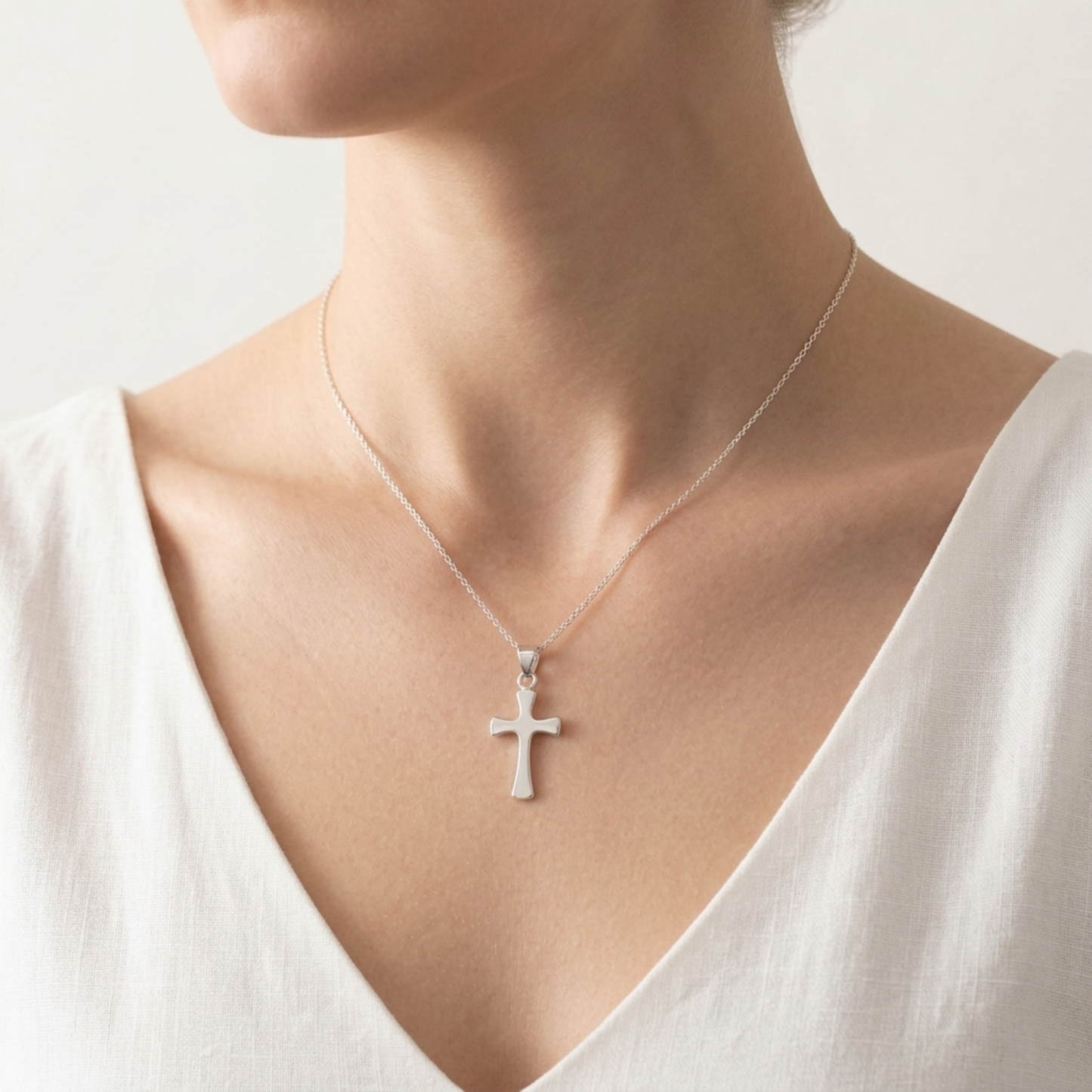Flared cross pendant necklace on a chain, polished silver cross