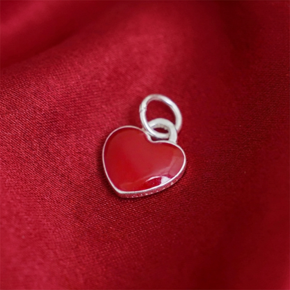 Red heart charm from side view, silver border around glossy enamel heart