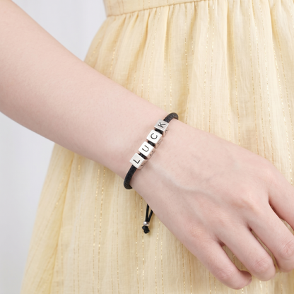 Alphabet cube bead bracelet on wrist with visible letters U, C, K, D, E