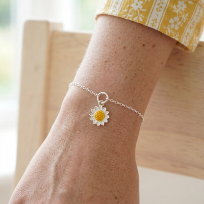 Pulsera con charm girasol esmaltado amarillo sobre eslabones plateados