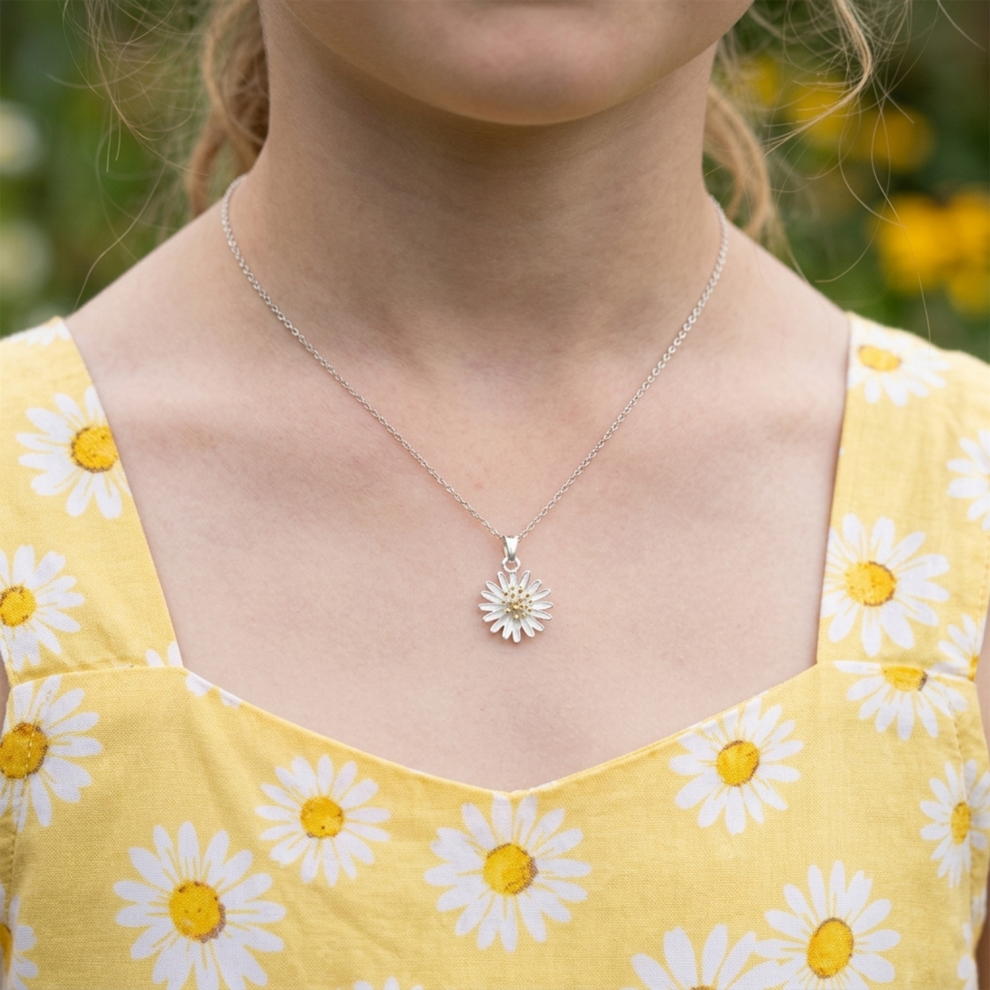 Silver daisy flower pendant necklace worn on model’s neck