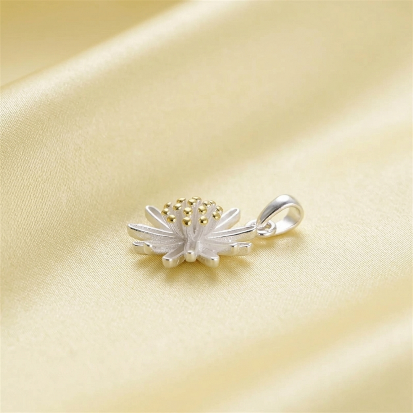 Silver daisy flower pendant with gold center, side view of bail