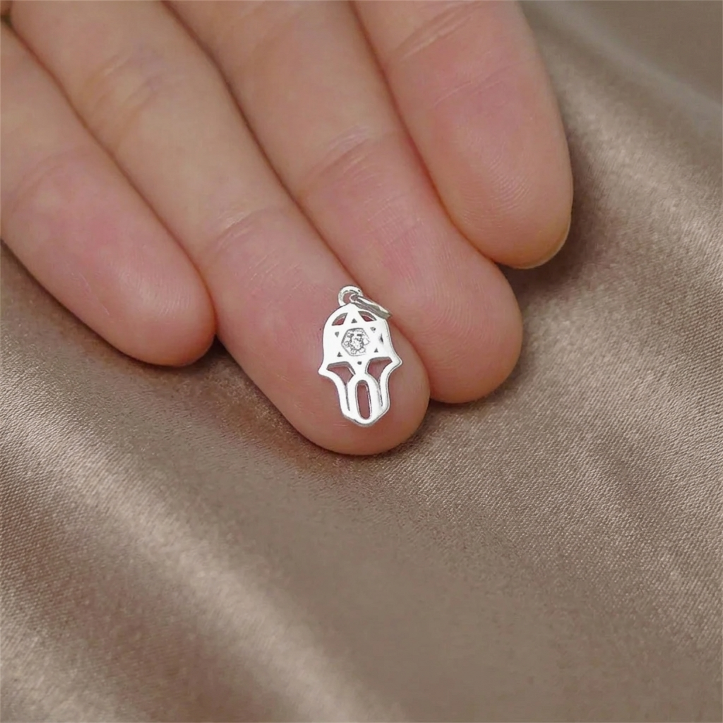 Silberner Hamsa-Schutzanhänger mit zentralem, glitzerndem Stein am Finger