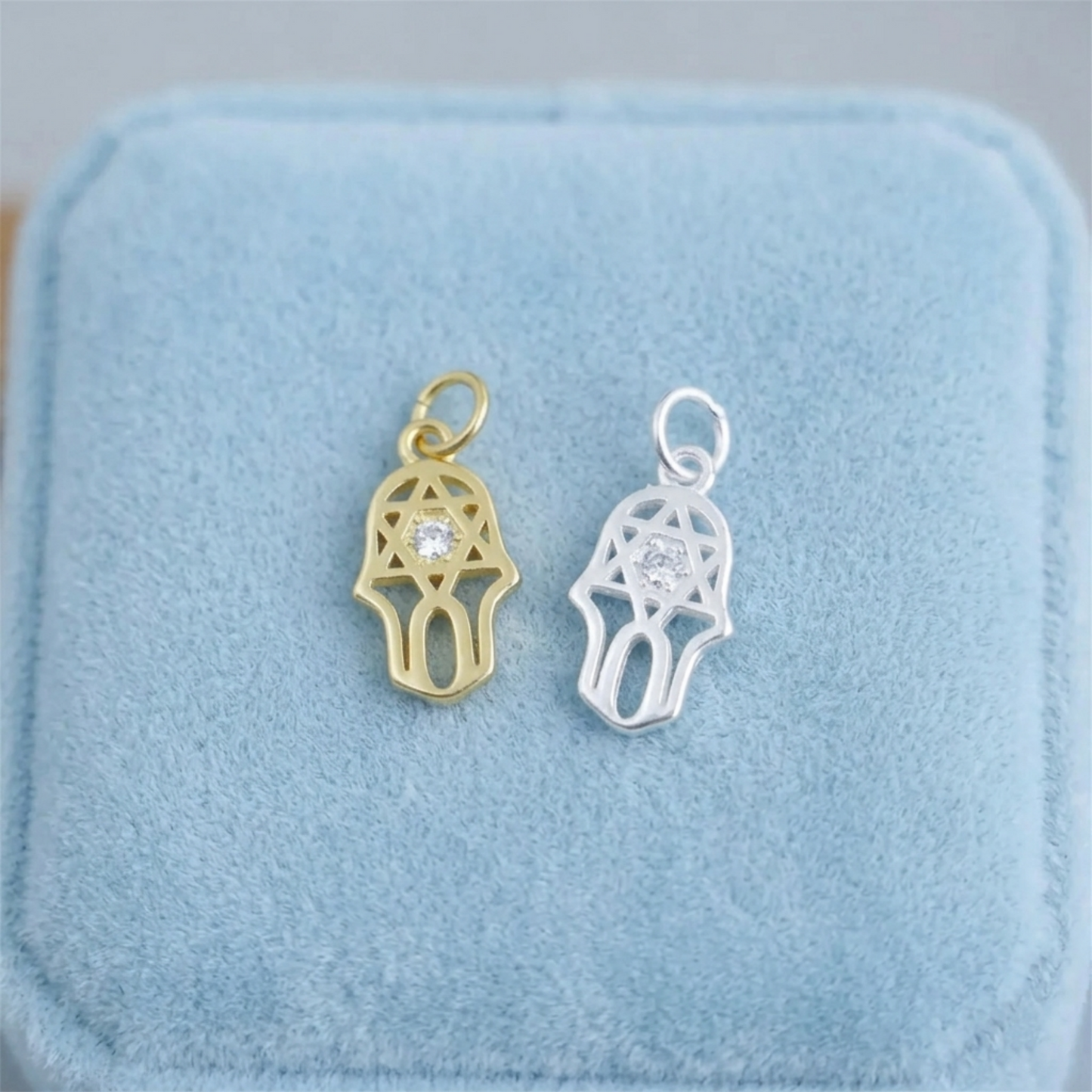 Gold- und Silberfarbene Hamsa-Schutzanhänger mit hellem Stein