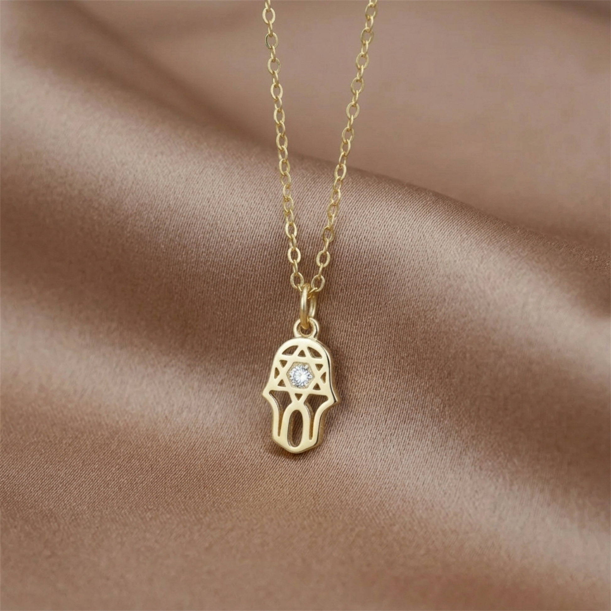 Goldener Hamsa-Schutzanhänger an Kette mit hellem Stein