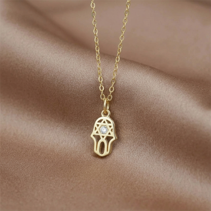 Goldener Hamsa-Schutzanhänger an Kette mit hellem Stein