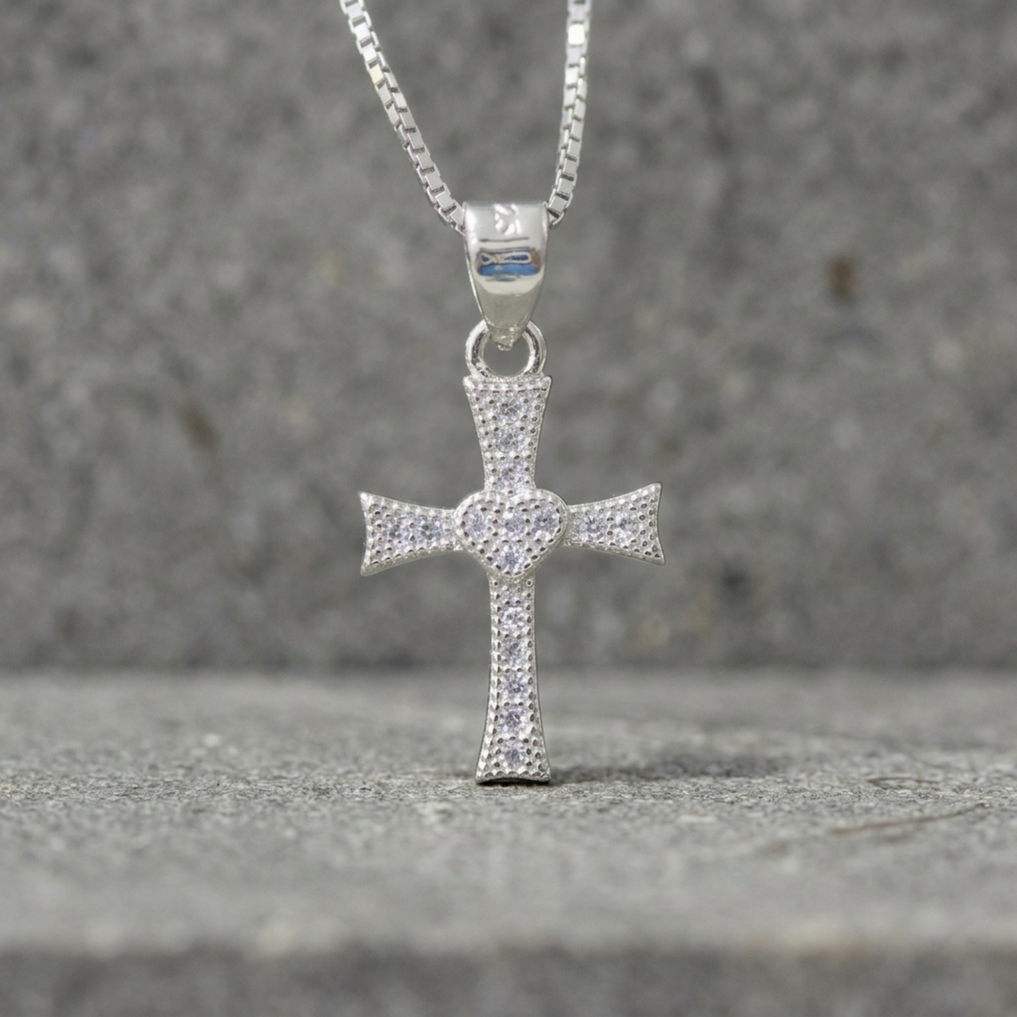 CZ heart cross pendant hanging on chain, silver-tone cross with pavé heart center