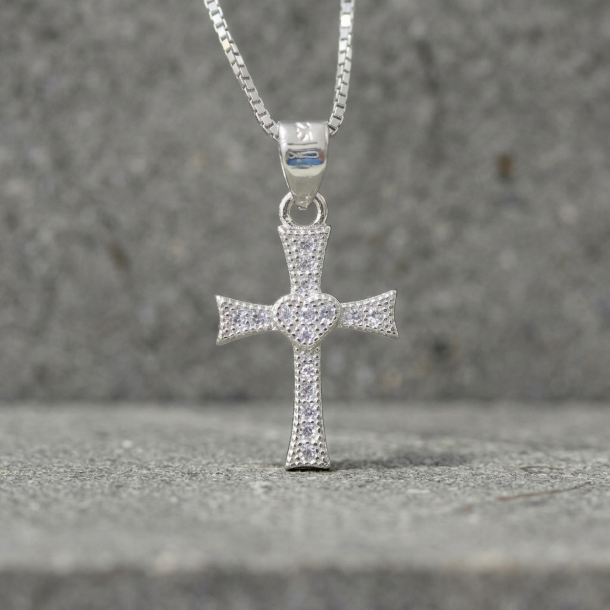 CZ heart cross pendant hanging on chain, silver-tone cross with pavé heart center