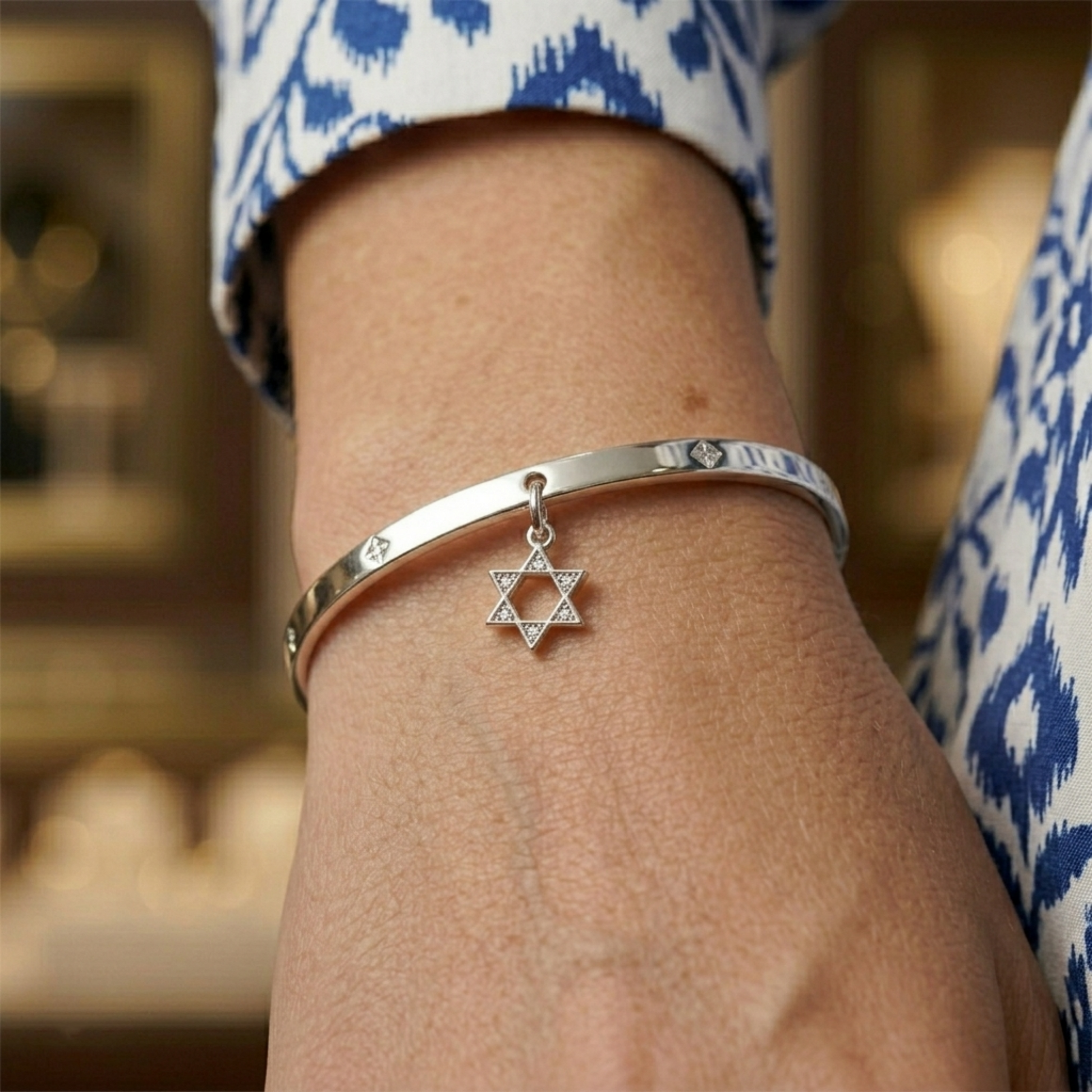 Silver-tone Star of David charm on a bracelet cuff, hexagram with stone details
