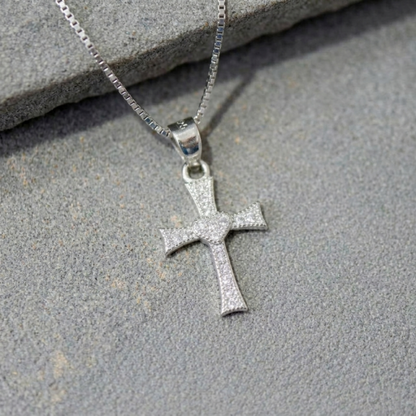 Close-up of CZ heart cross pendant, small heart at center on silver-tone cross