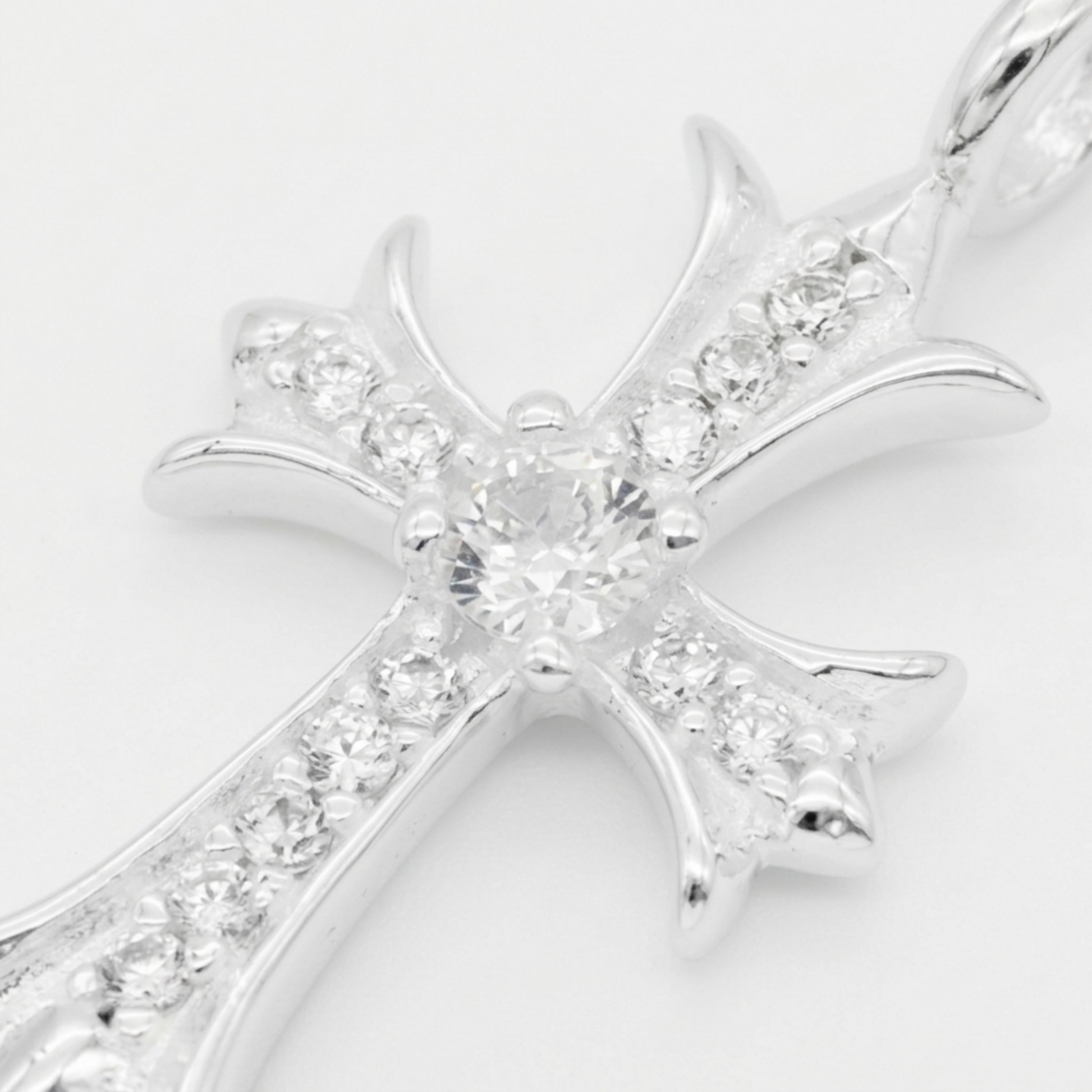 Silver CZ cross pendant close-up with large center stone and pavé details