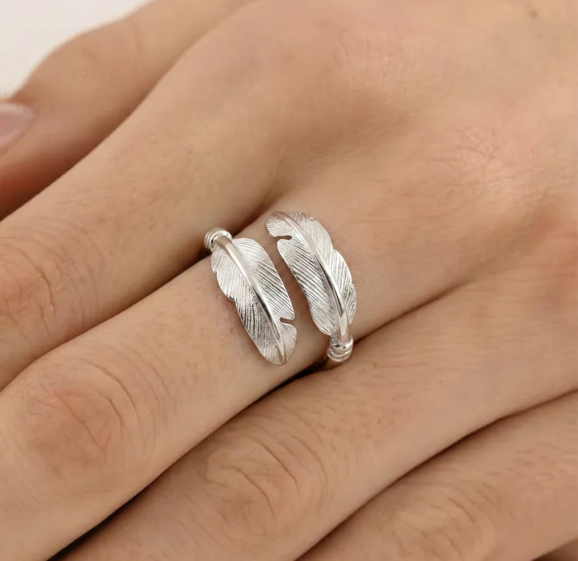 Feather motif open band ring on hand, silver tone