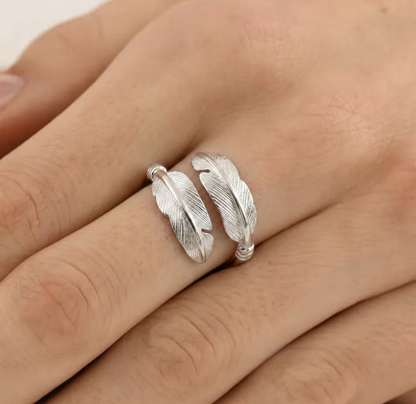 Feather motif open band ring on hand, silver tone