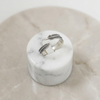 Feather Wing Wrap Ring, zwei übereinanderliegende Federdetails auf schmalem Metallband