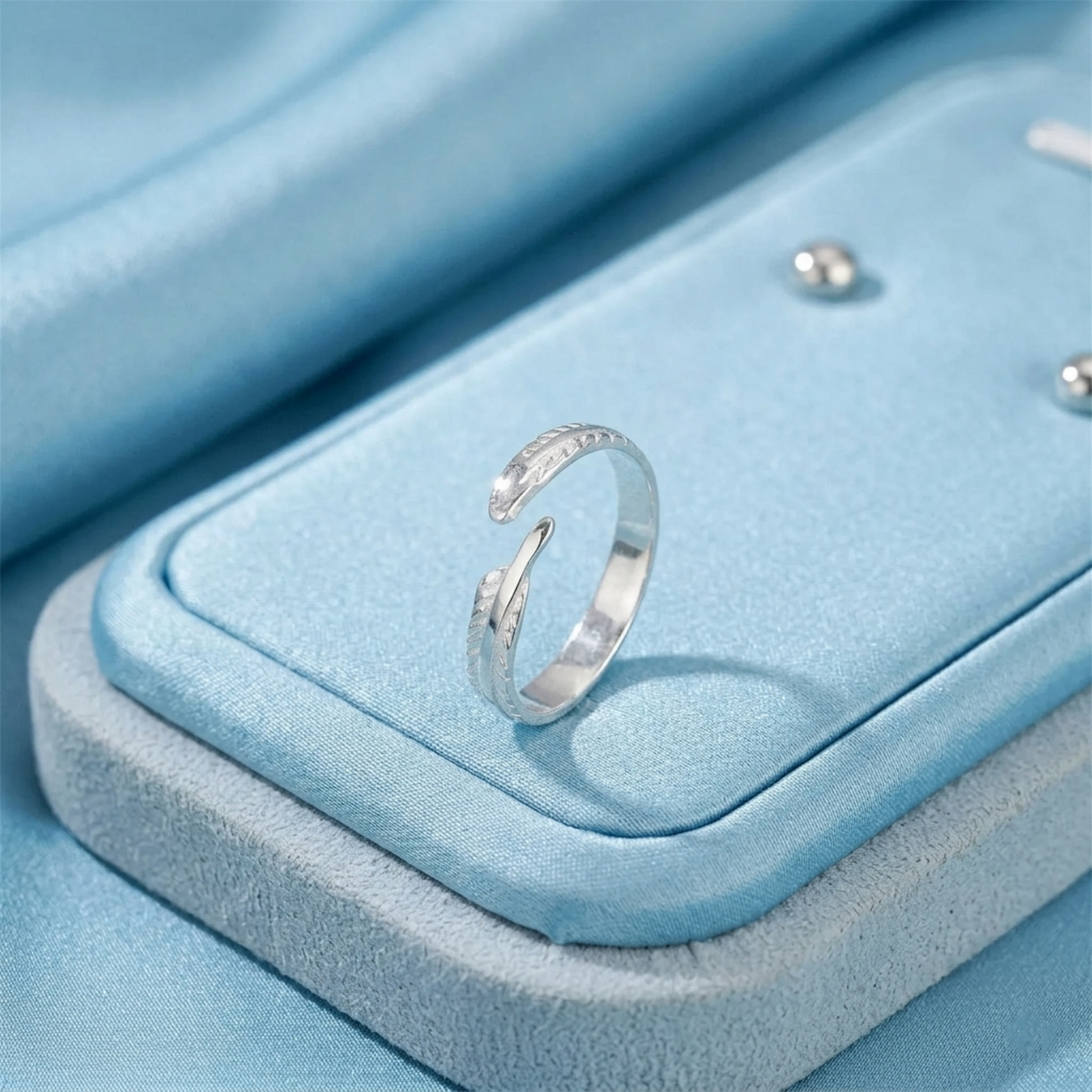 Angel feather wing open ring on a blue jewelry box, silver-tone feather design