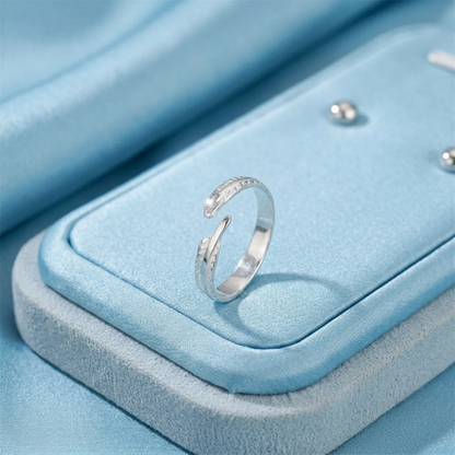 Angel feather wing open ring on a blue jewelry box, silver-tone feather design