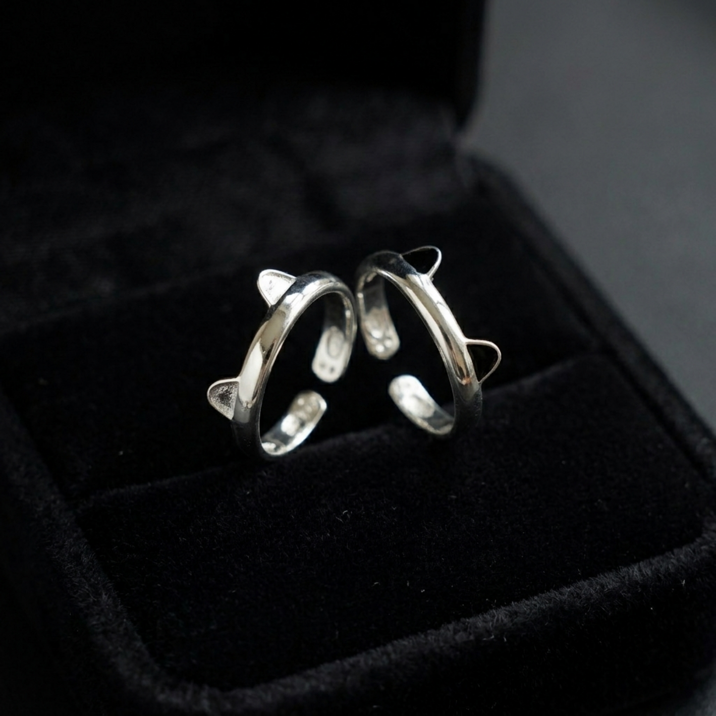 Silver-toned cat paw ring with black enamel tips shown in black jewelry box