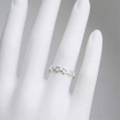 Star link ring on a hand, silver-tone band with small star charms
