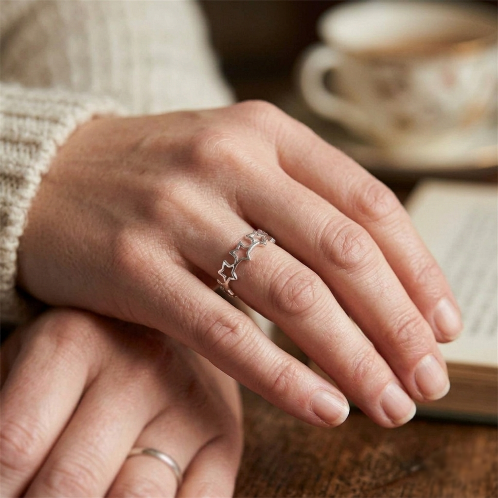 Linked Lucky Stars ring on finger, silver-tone star links detail