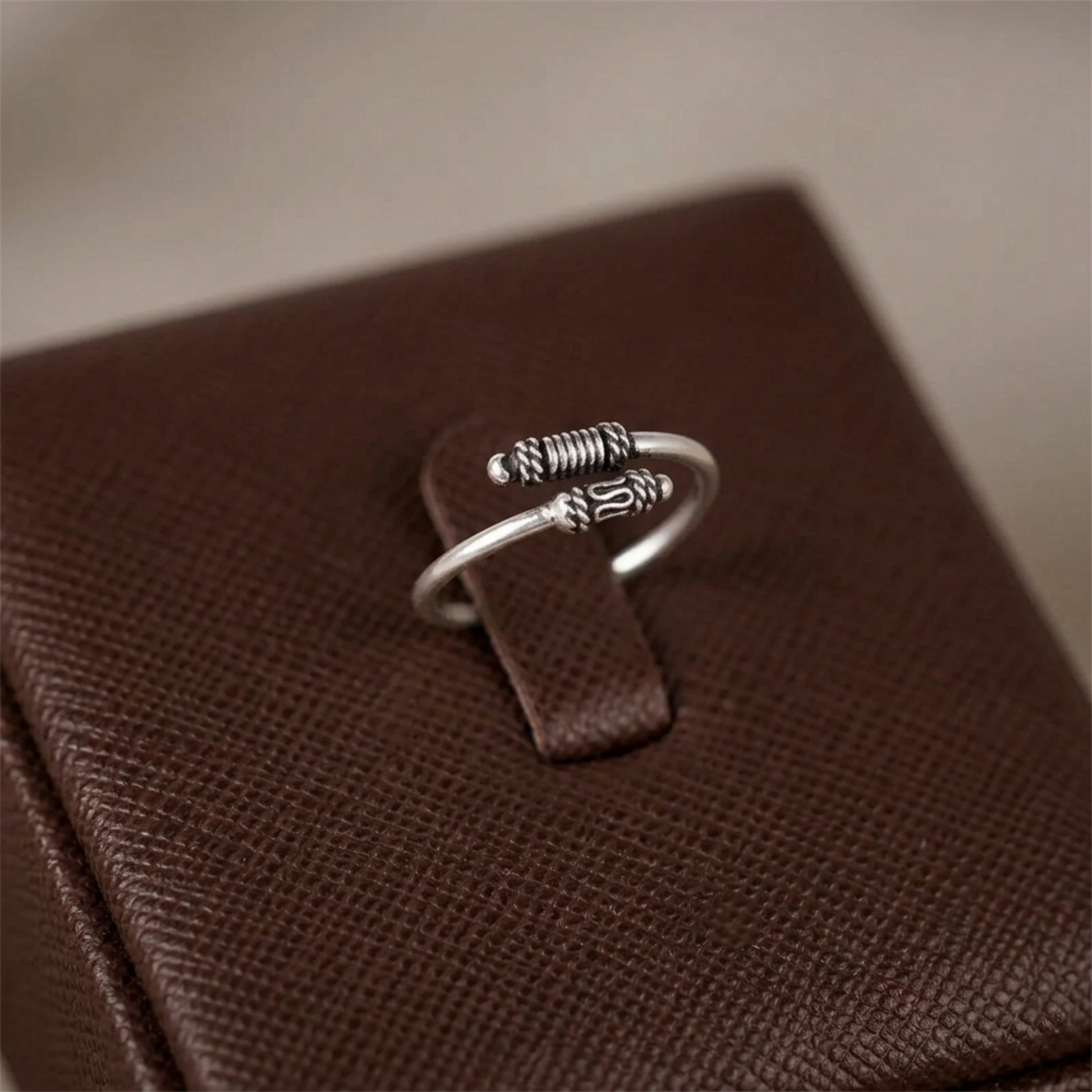 Oxidised Totem Knot ring, silver tone with spring-like ridges and knot centerpiece
