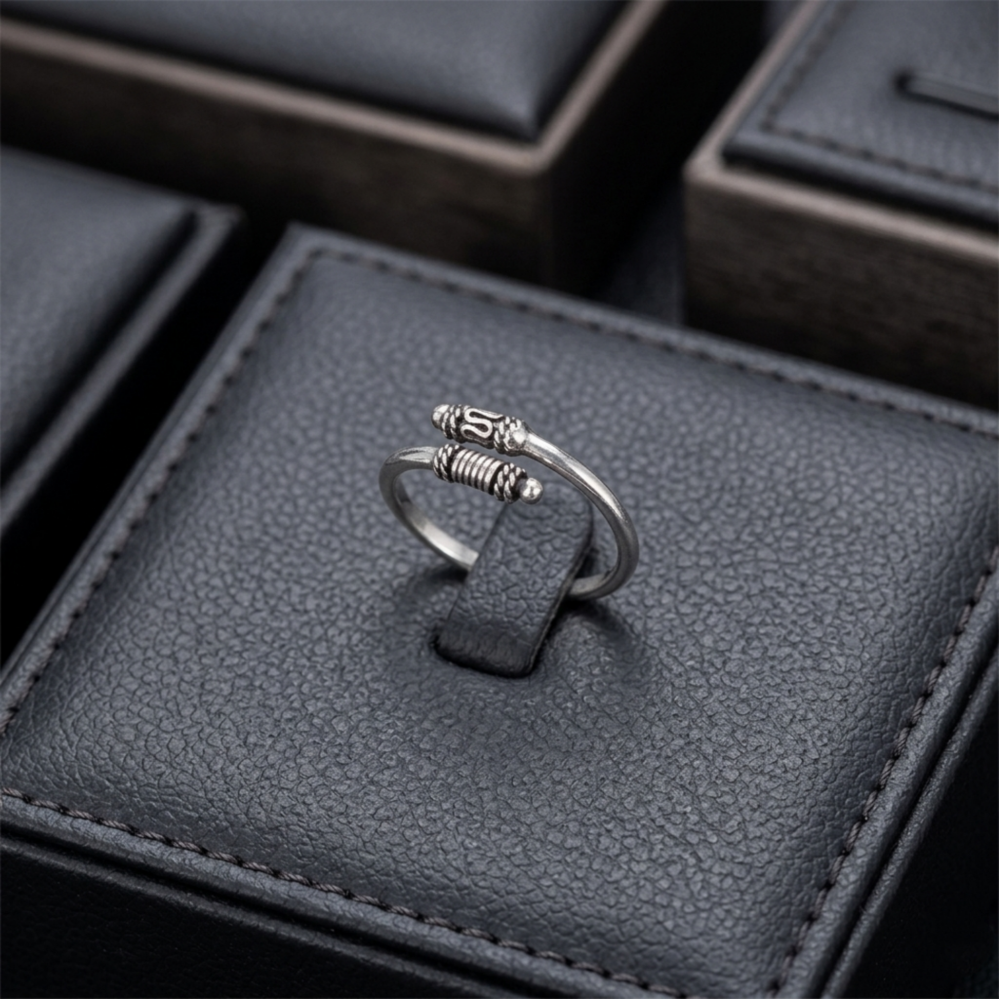 Oxidised Totem Knot ring on finger, silver tone with spring ridges and knot centerpiece