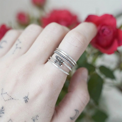 Oxidised Totem Knot ring stack on finger, silver tone ridged knot design