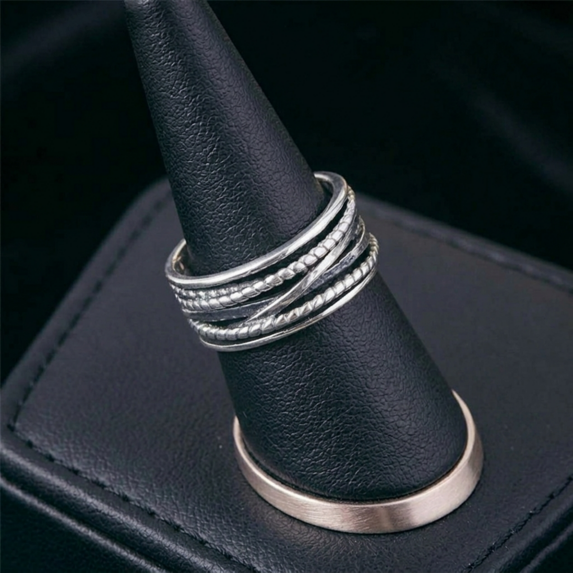 Oxidised rope crossover ring worn on finger, stacked rope and etched crossover bands