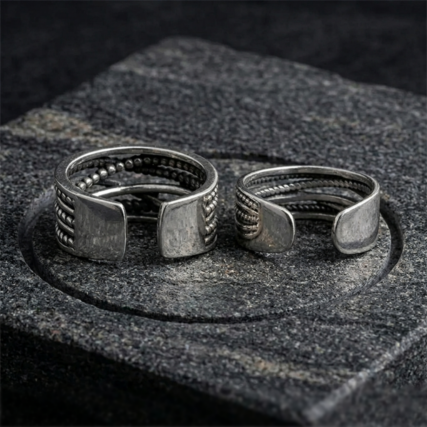 Oxidised rope crossover ring pair on stone, square-cut crossover ends