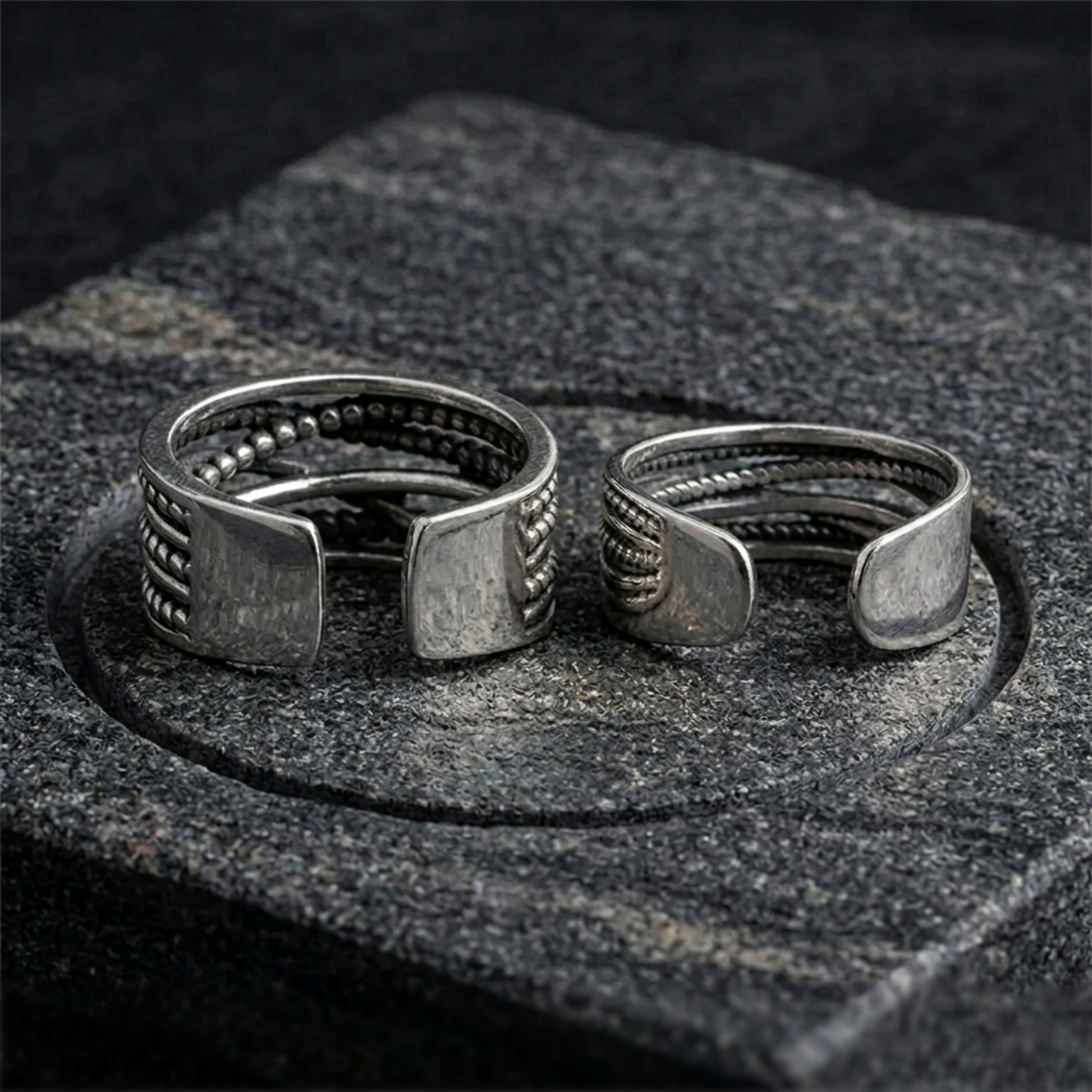 Oxidised rope crossover ring pair on stone, square-cut crossover ends