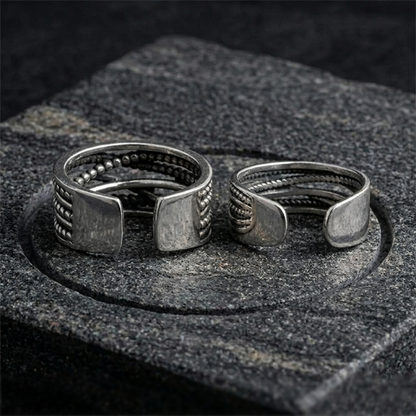 Oxidised rope crossover ring pair on stone, square-cut crossover ends