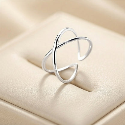 Silver criss-cross love knot ring, interwoven open bands close-up.
