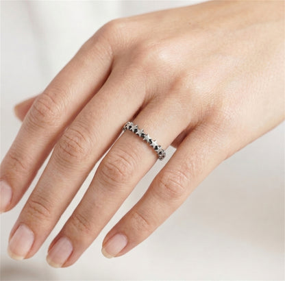 Oxidised linked stars ring on finger, silver-toned band with star motifs