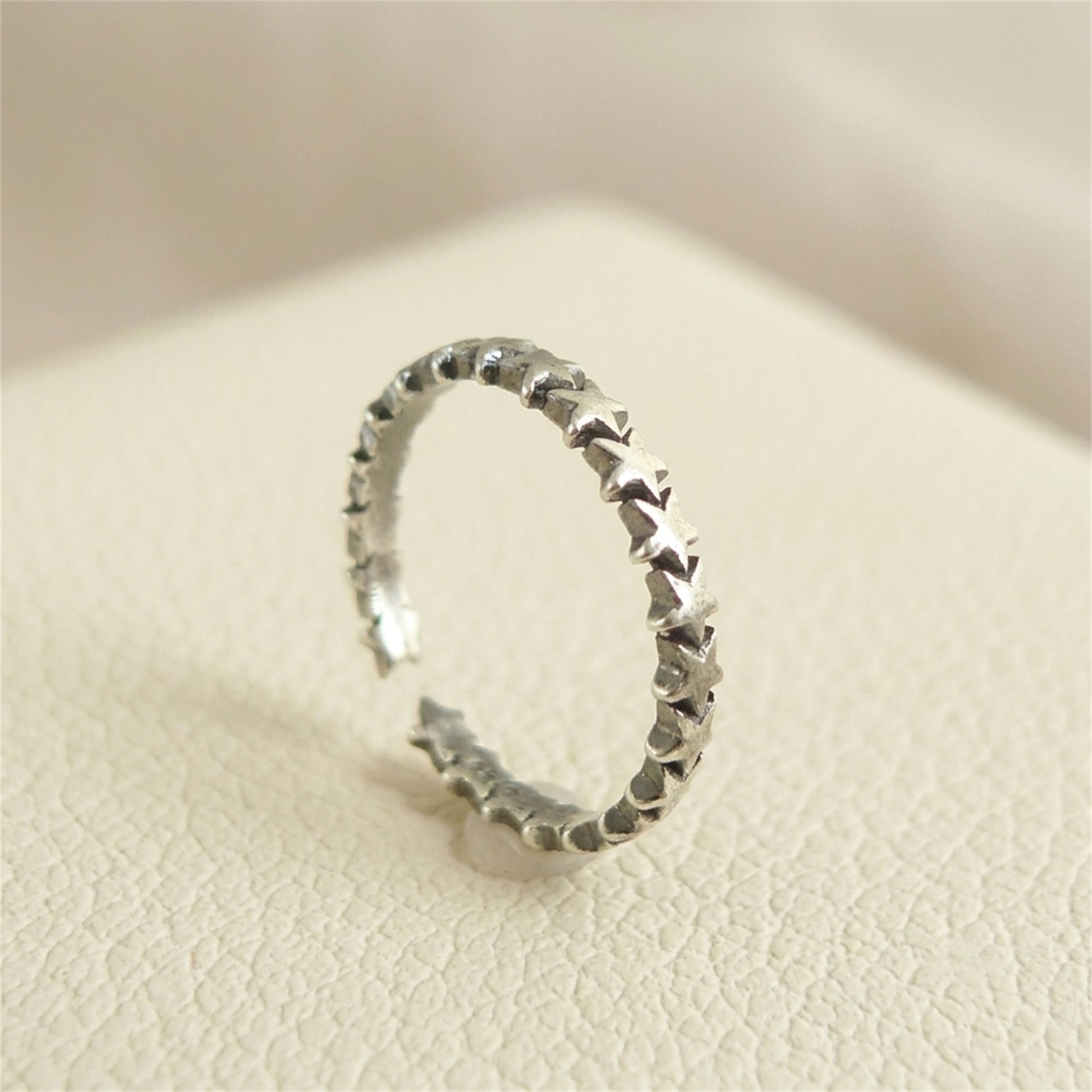 Oxidised linked stars ring, close angle showing star-link texture on silver band